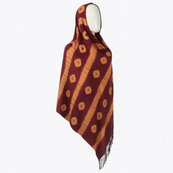 Maroon Adire scarf with diagonal orange dotted lines and fringe hem, styled on a mannequin.