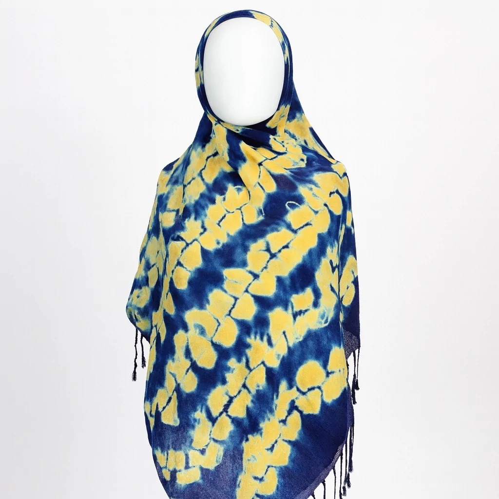 Blue Adire scarf with scattered yellow tie-dye patterns, draped in front view on a mannequin.