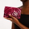 Hand holding an Ankara African print card holder with pink swirl design, showing compact size.