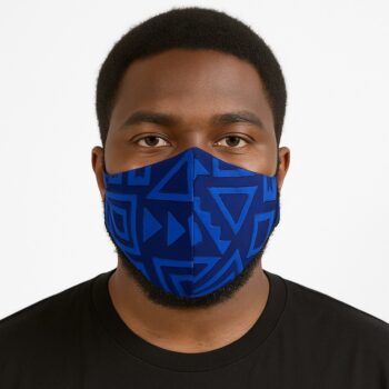 Close-up of a man wearing a blue Ankara face mask with geometric triangle and arrow patterns. Front view on white seamless background.