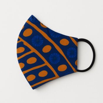 Flat lay photo of six colorful Ankara face masks arranged in a circle with decorative balls. Each mask features unique African patterns. White surface background.