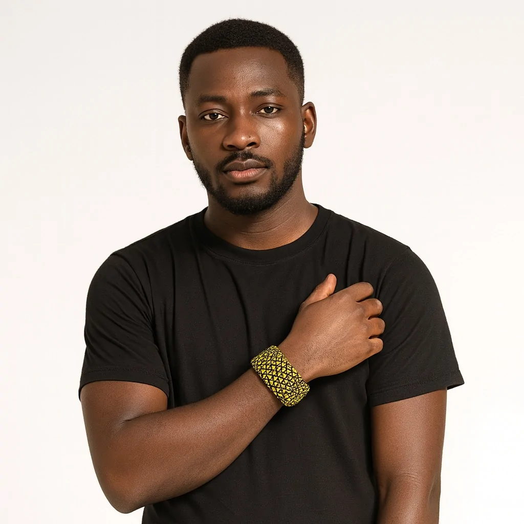 Handsome Black man wearing a black T-shirt and modeling a yellow and black triangle patterned Ankara bangle.