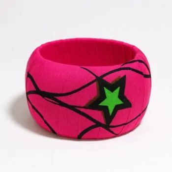 Bold pink Ankara bangle with a large green star and flowing black line patterns, placed on a white background.
