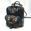 Studio product shot of a black leather backpack with bold geometric Ankara print flap and side pocket.