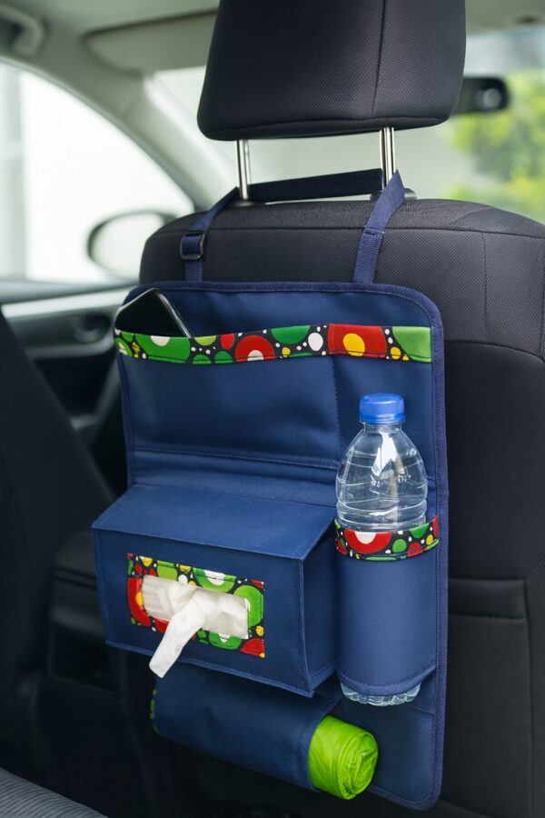 Backseat car organizer in navy blue with multicolor Ankara trim, featuring compartments for water bottle, tissue box, and phone.