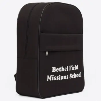 Side-angled view of the black school backpack with "Bethel Field Missions School" branding and zippered front pocket.