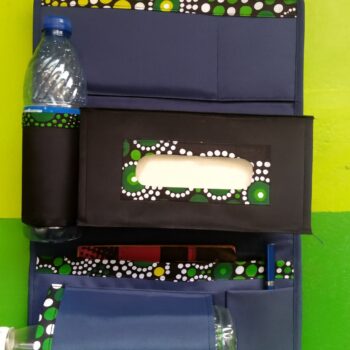Colorful African-inspired backseat organizer with black tissue box and multiple storage pockets, styled with green and white Ankara trim.