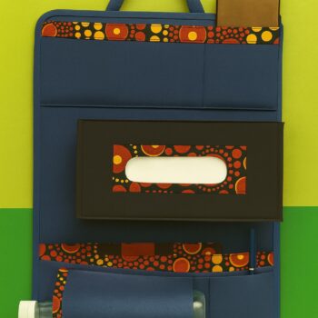 Clean studio image of blue and black car organizer with orange Ankara print details, showcasing phone pocket, tissue slot, and bottle holder.