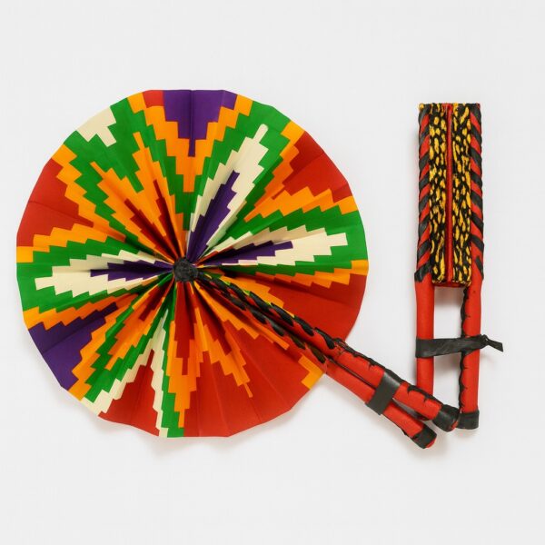 Round African print hand fan with bold zigzag pattern in red, green, orange, purple, and cream. Folded and secured with black leather straps, shown next to its folded form.