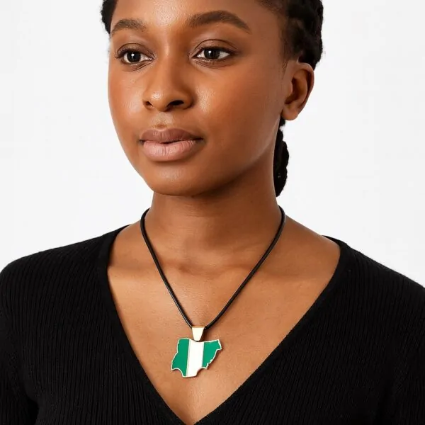 Female model in black V-neck wearing a Nigeria-shaped pendant necklace with a gold trim.