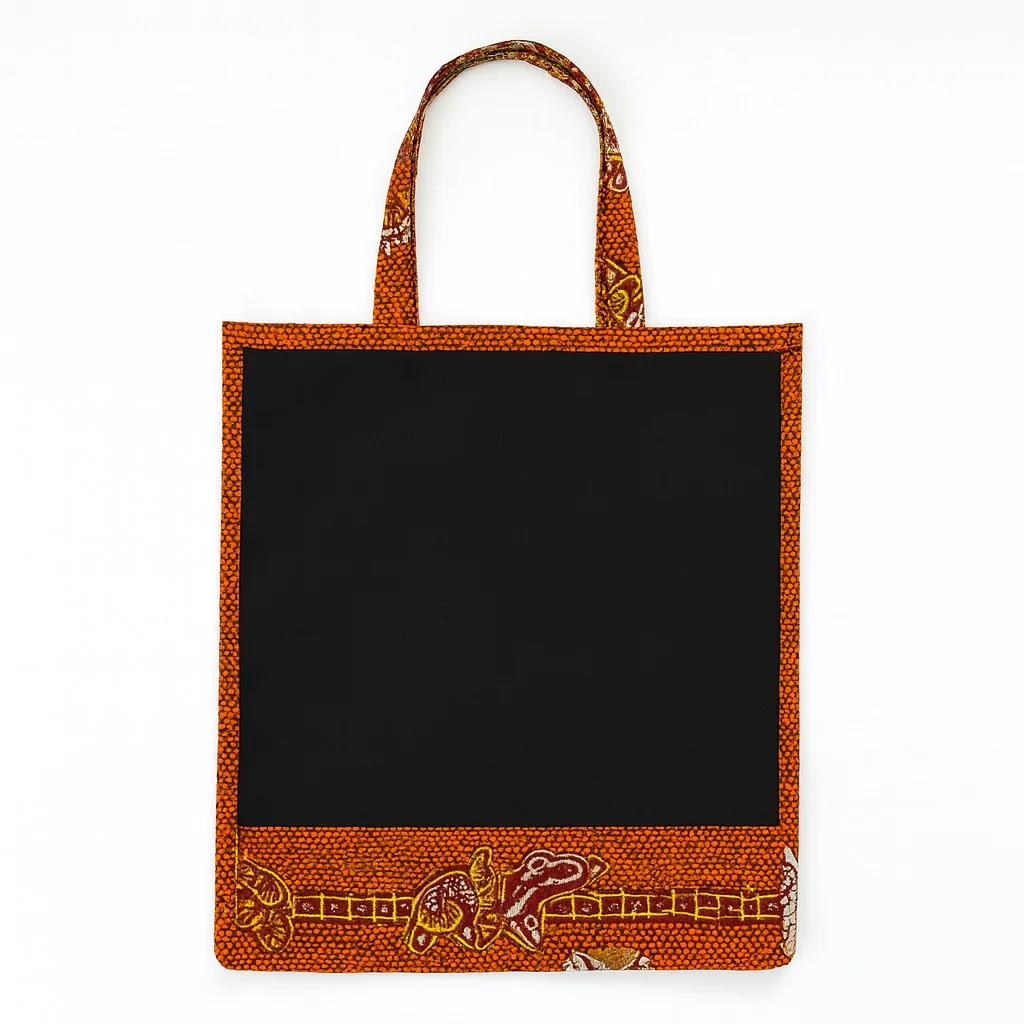 Black tote bag with orange Ankara print border and decorative base