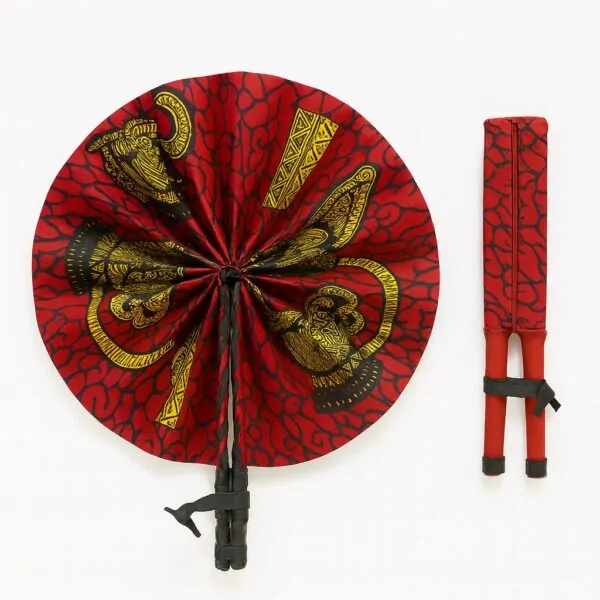 Red Ankara hand fan featuring golden elephant motifs and abstract vine patterns. Presented fully open and folded, with black leather binding.