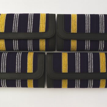 Four African print Ankara ladies' purses – navy background with gold and silver vertical stripes, trimmed with black leather, arranged in two rows on a white background.
