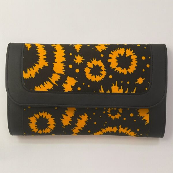 Single African print Ankara ladies' purse – black background with bright yellow starburst and circular patterns, trimmed with black leather, displayed on a white background.
