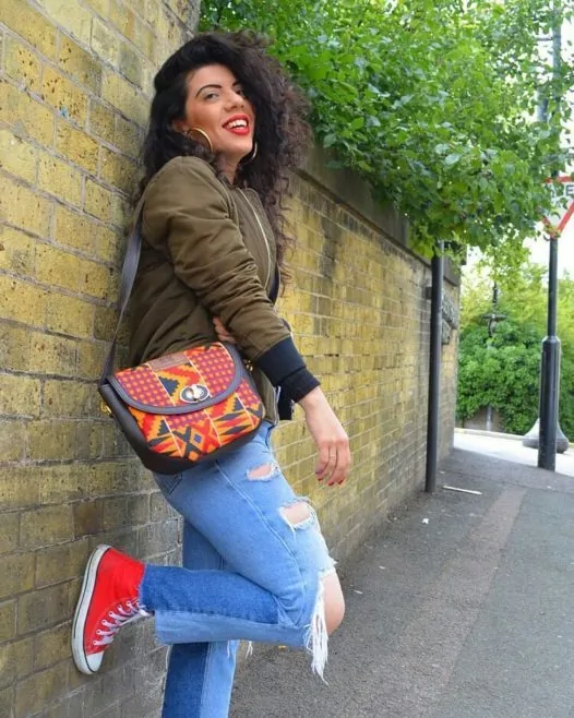 Handmade Souvenir Bags in Nigeria | Unique + Personalized 7 A lady carrying an African Things red patterned Amar crossbody bag.