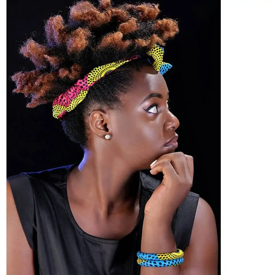 Black African lady with African print head tie and wrist band.
