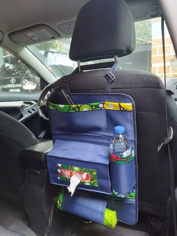 Light blue branded car organizer with accessories in different sections.