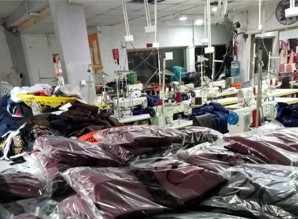 A plain t-shirt making factory with machines, finished t-shirts and other cloth accessories.