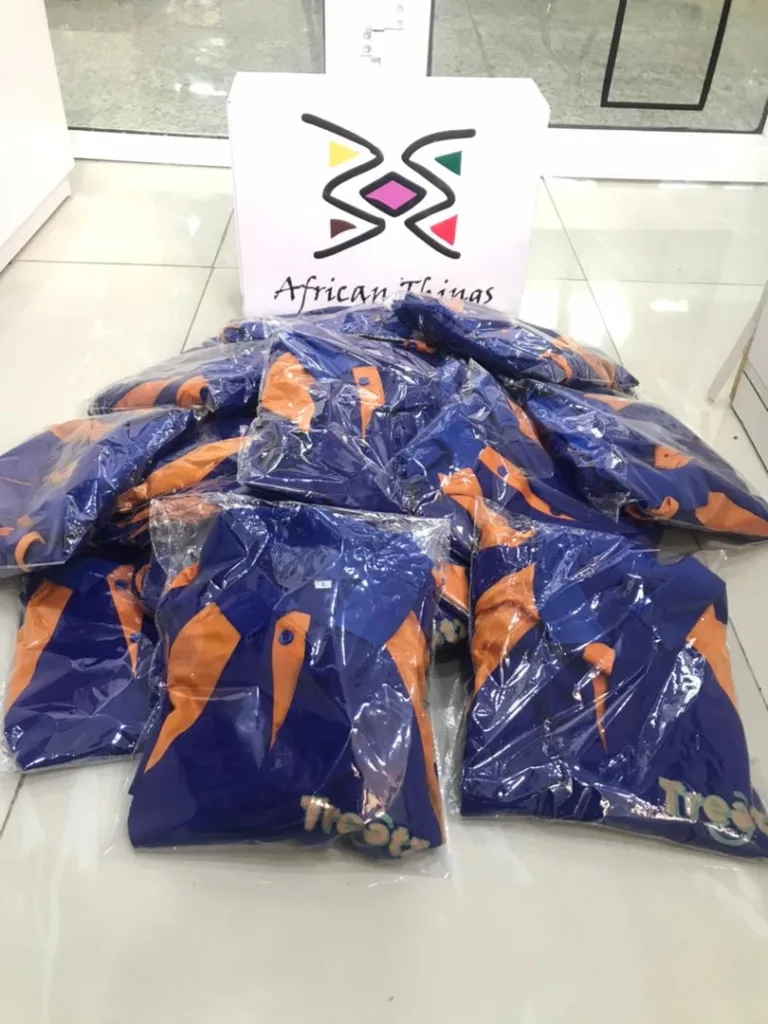 Multiple customized t-shirts packaged and placed on the floor.