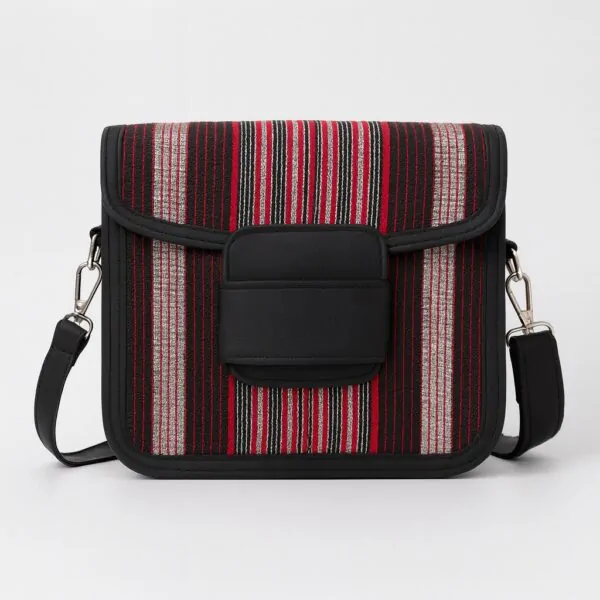 Front view of an African print Aso Oke side bag with red, black, and silver vertical stripes, black leather flap, and shoulder strap on a white background.