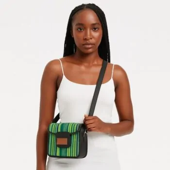 Elegant African woman in a white dress wearing a green and yellow Aso Oke side bag crossbody-style.