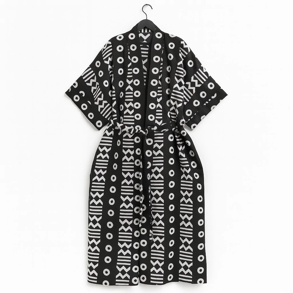 Black kimono with white tribal and geometric patterns, displayed on a hanger.