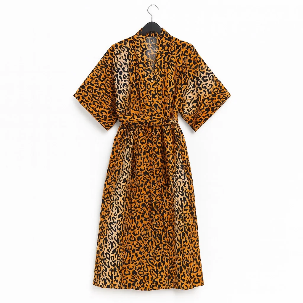 Orange and black leopard print kimono with a matching belt on a hanger.