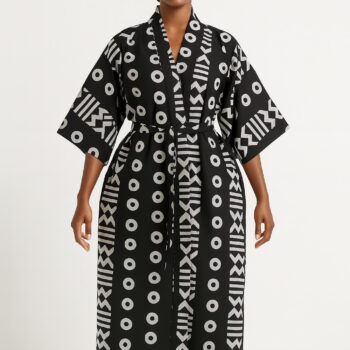 Woman wearing a black kimono with white tribal patterns, standing barefoot.