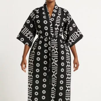 Woman wearing a black kimono with white tribal patterns, standing barefoot.