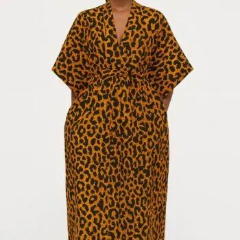 Woman wearing an orange and black leopard print kimono, standing barefoot.