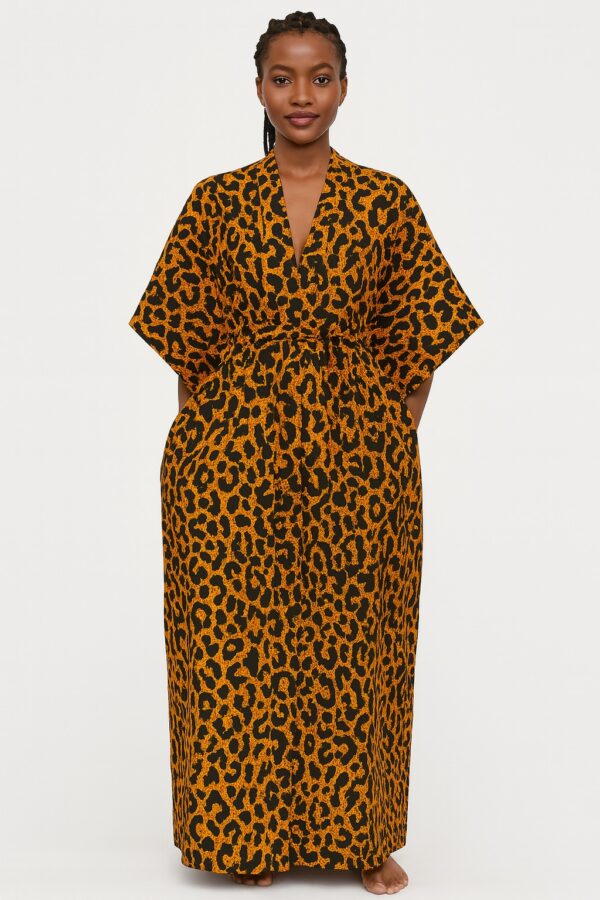 Woman wearing an orange and black leopard print kimono, standing barefoot.