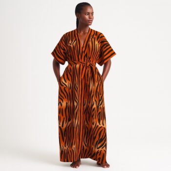 Woman wearing an orange and black tiger-striped kimono with a tied belt, posing barefoot.
