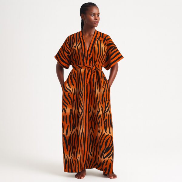 Woman wearing an orange and black tiger-striped kimono with a tied belt, posing barefoot.