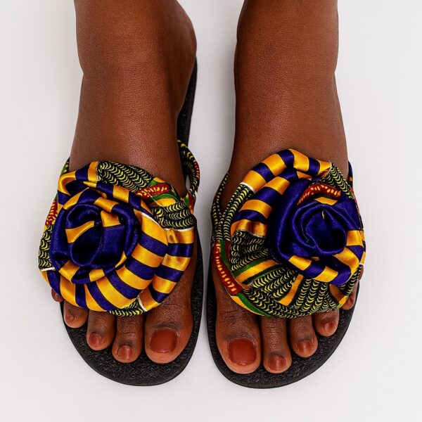 Women's African print flip-flops with yellow and blue rose design on dark feet.