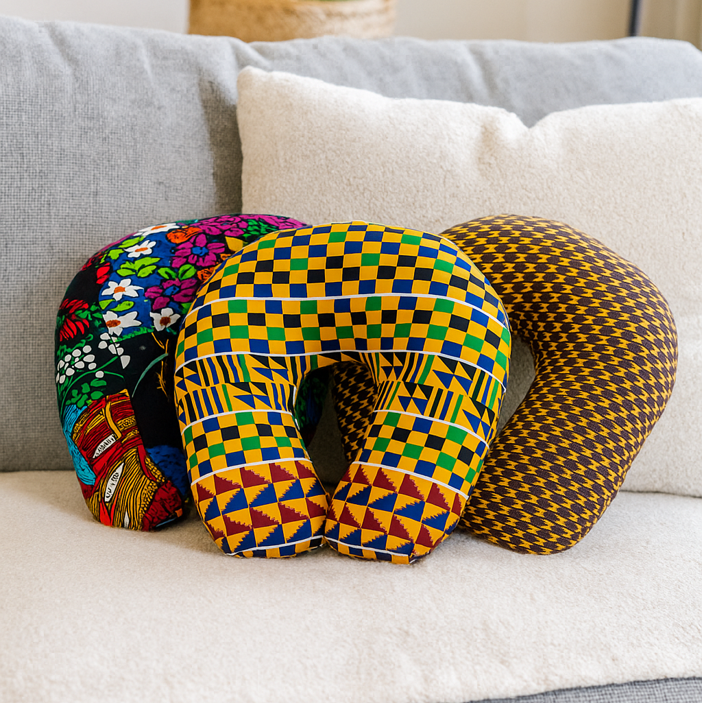 Vibrant African print neck pillows on a cushion in a living room.