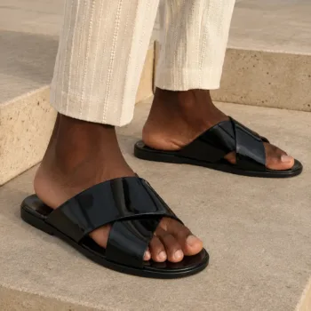 Male model wearing a handmade sleek black slide sandal criss cross