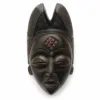 African wooden mask with carved geometric details and elongated headdress