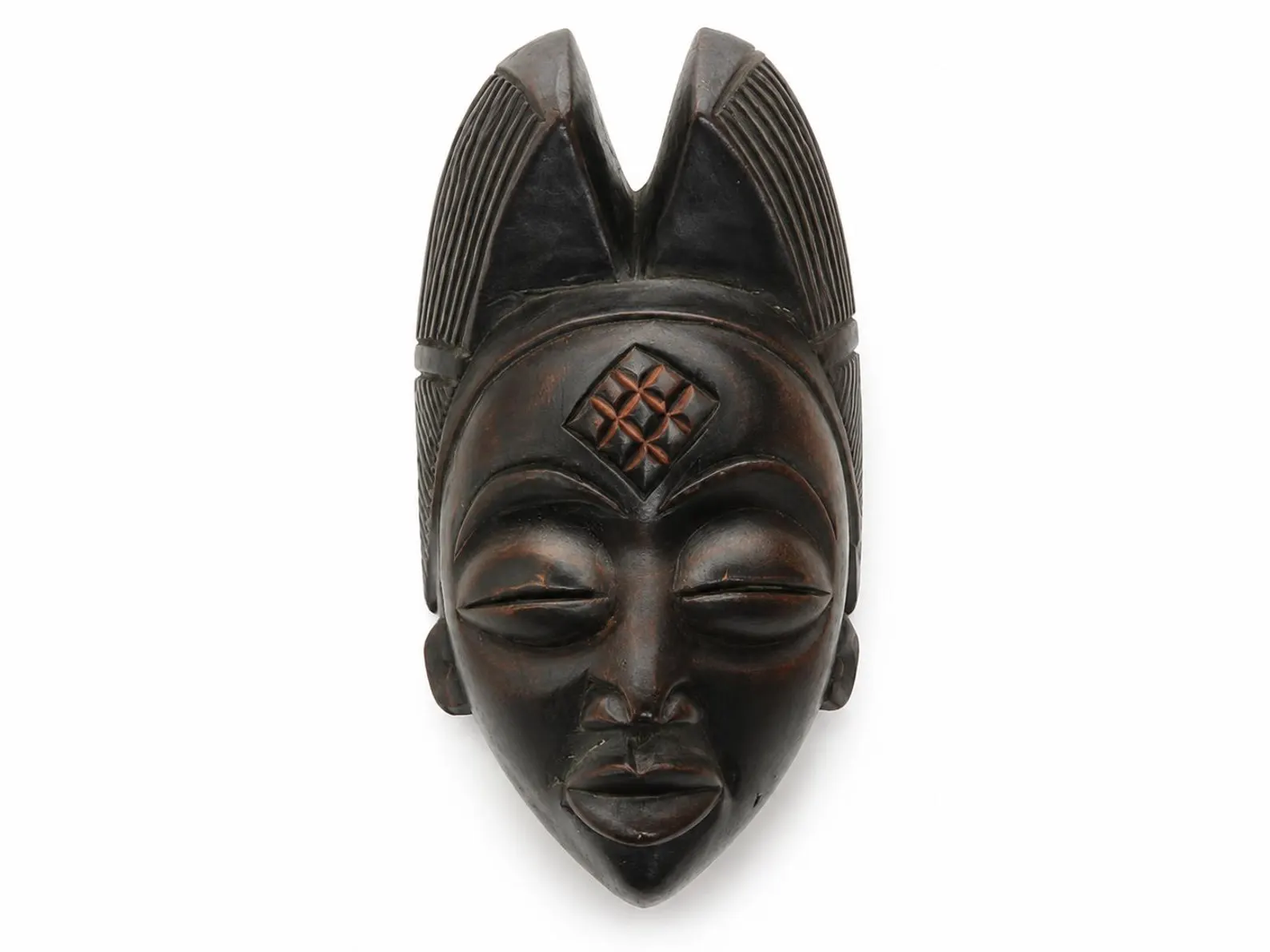 African wooden mask with carved geometric details and elongated headdress