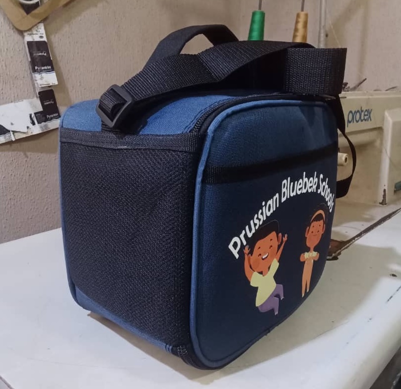 See how African Things produced 123 branded backpacks and lunch boxes for Prussian Bluebek Schools. Bulk school bag and lunch box manufacturing for schools in Nigeria.