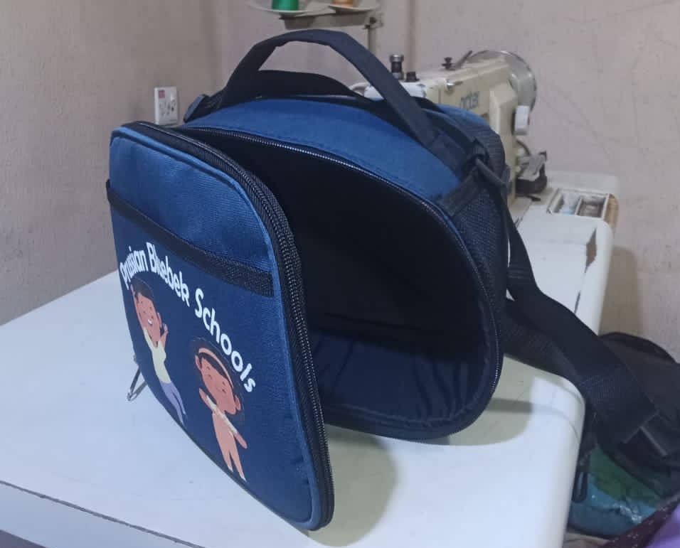 See how African Things produced 123 branded backpacks and lunch boxes for Prussian Bluebek Schools. Bulk school bag and lunch box manufacturing for schools in Nigeria.