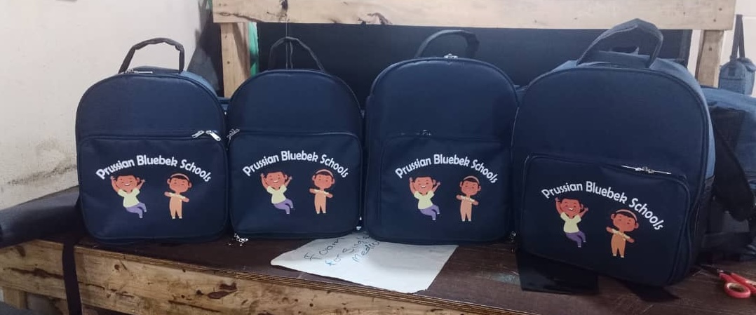 See how African Things produced 123 branded backpacks and lunch boxes for Prussian Bluebek Schools. Bulk school bag and lunch box manufacturing for schools in Nigeria.